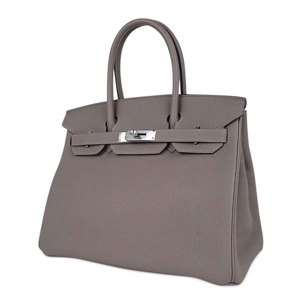 Sophisticated Muted Greige Pebble Grain Medium Structured Trapezoid Tote With Sleek Silvery Twist Lock Hardware And Hanging Decorative Metal Padlock Charm