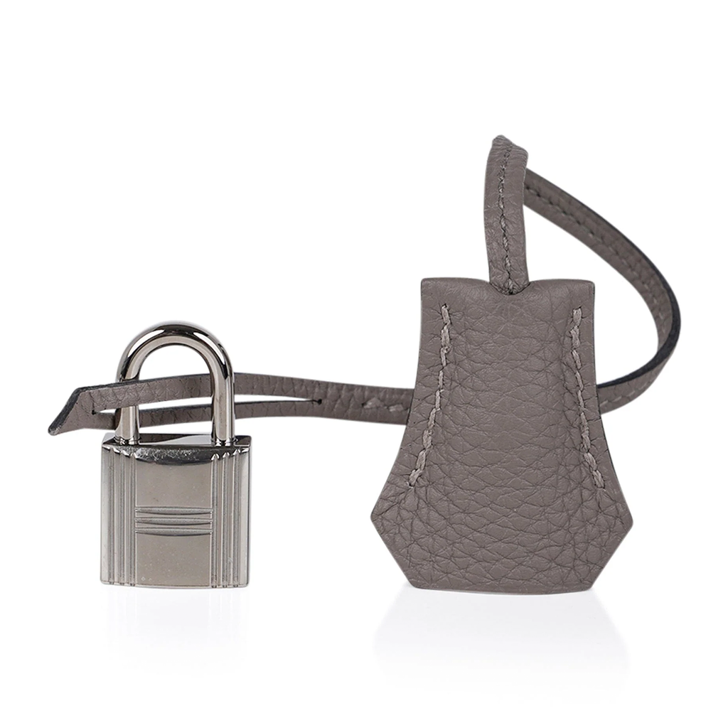 Sophisticated Muted Greige Pebble Grain Medium Structured Trapezoid Tote With Sleek Silvery Twist Lock Hardware And Hanging Decorative Metal Padlock Charm
