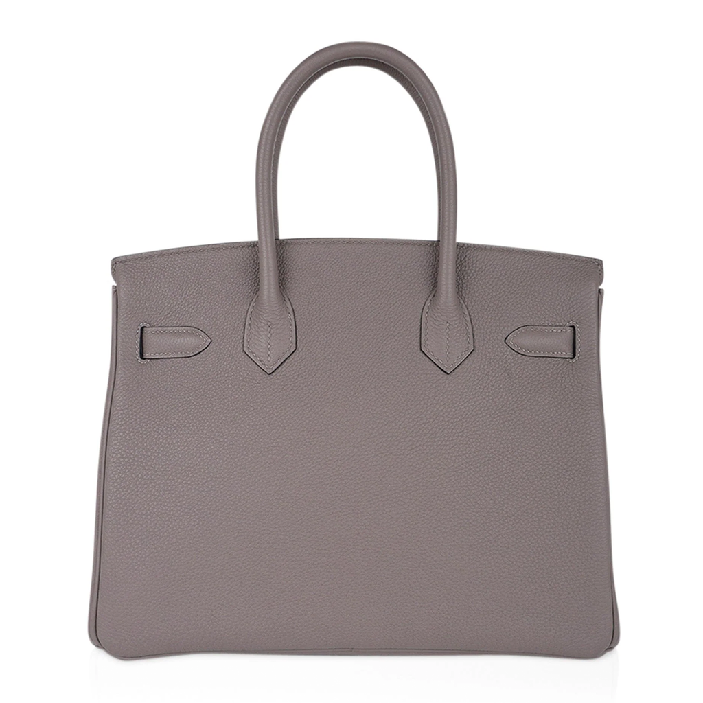 Sophisticated Muted Greige Pebble Grain Medium Structured Trapezoid Tote With Sleek Silvery Twist Lock Hardware And Hanging Decorative Metal Padlock Charm